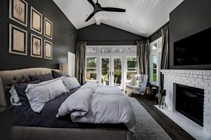 Bedroom with double glass doors and door size windows leading to a back patio