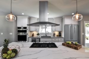 Kitchen with stove built into island, kitchen hood above. Palos Verdes, CA