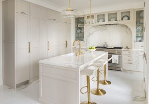 Bright white kitchen with gold accents and a hidden kitchen hood. 