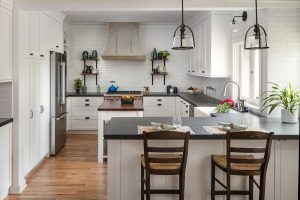 Modern Farmhouse Kitchen with Soapstone Counters, a butcher block island top, and a beautiful kitchen range hood. 