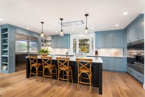 Blue Cabinets with dark wood island and marble countertops remodeled by Zieba Builders
